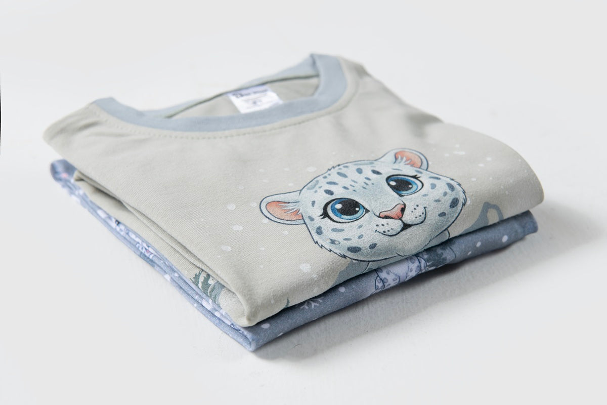 Folded blue snow leopard Christmas pyjamas showcasing premium cotton fabric and festive winter print.