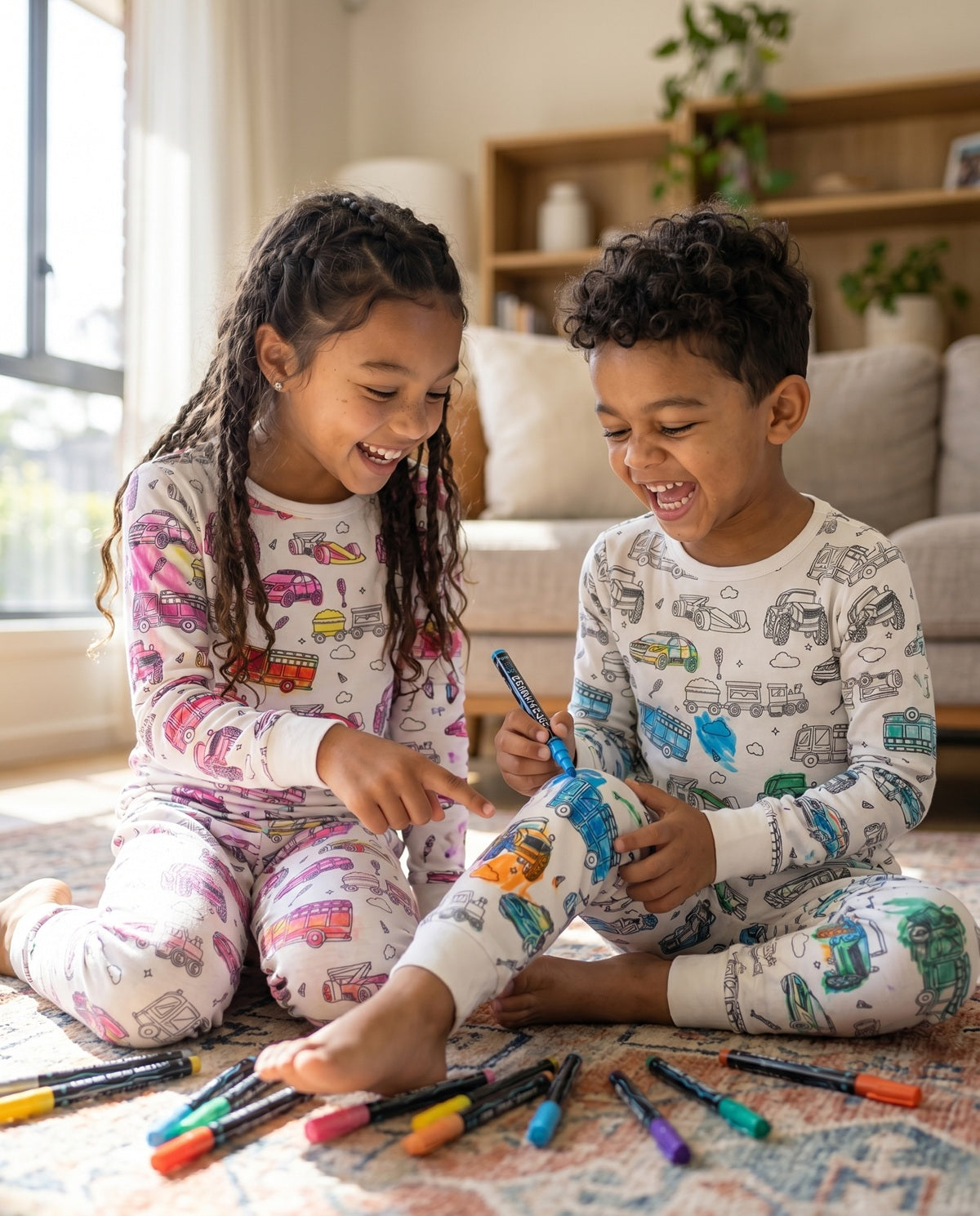 Brother and sister colouring their Vehicles Colour-In Pyjamas with fabric pens before bedtime.